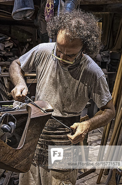 Craftsman working on a forcola (Venetian rowlock) Paolo Brandolisio's workshop; Venice Italy
