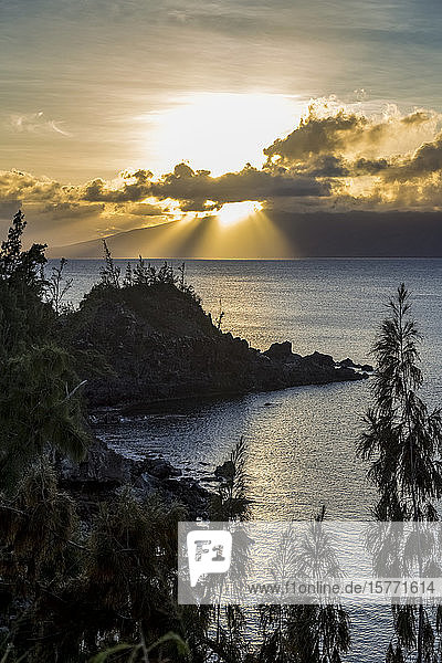 Maui Küstenlinie Silhouette durch den Sonnenuntergang und helle Sonnenstrahlen kommen durch die Wolken über dem Pazifischen Ozean. Ein perfekter Aussichtspunkt auf der Bergspitze der Küste für Touristen und Einheimische  um den Sonnenuntergang zu genießen; Maui  Hawaii  Vereinigte Staaten von Amerika