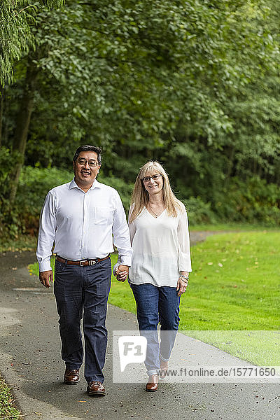 Portrait of a mature couple walking together down a trail; Langley  British Columbia  Canada