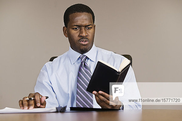 A Business man reading in an office.