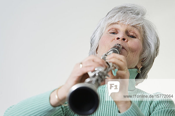 Portrait of a mature woman playing a clarinet.
