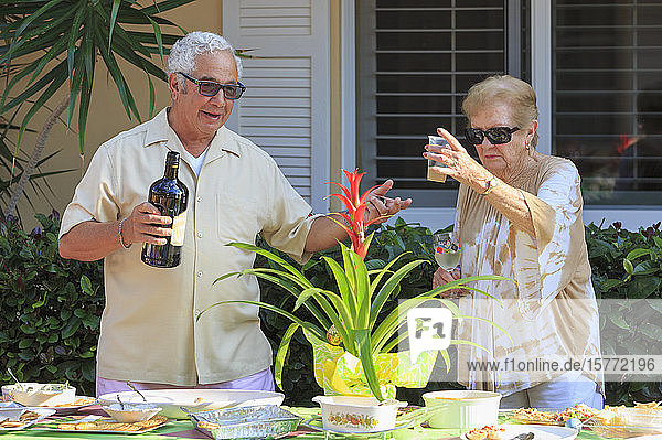 Älteres Paar mit alkoholischen Getränken bei einer Mahlzeit im Freien