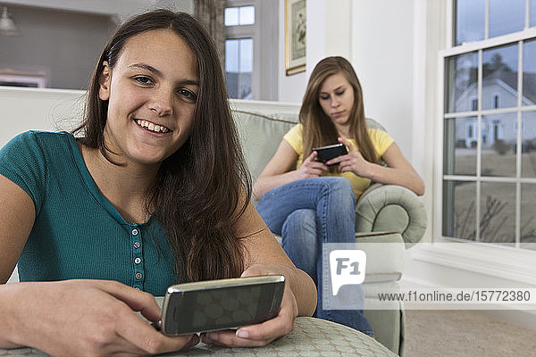 Zwei Mädchen im Teenageralter benutzen Smartphones