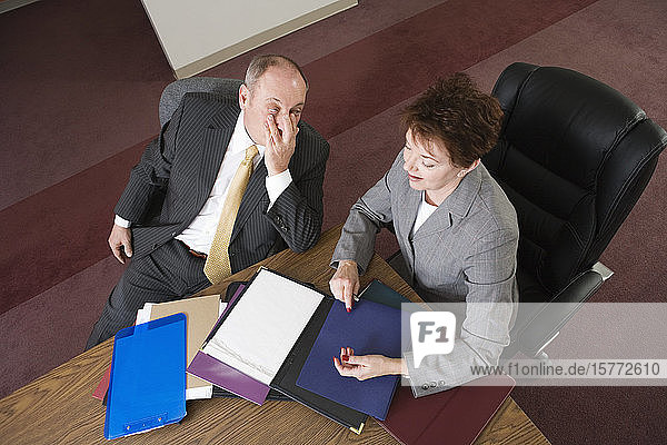 Blick von oben auf einen frustrierten Geschäftsmann und eine Geschäftsfrau.