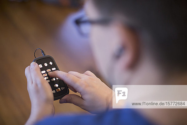 Young adult male using a remote control and earphones