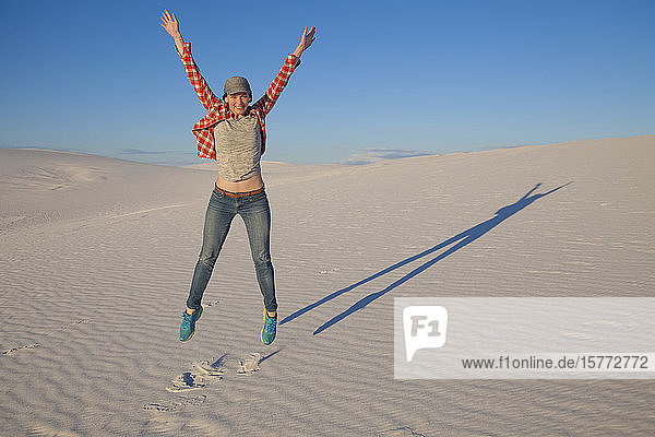 Carefree young woman on the white sand with blue sky White Sands National Monument; Alamogordo New Mexico United States of America