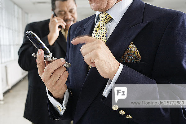 Blick auf einen Geschäftsmann  der ein Mobiltelefon benutzt.