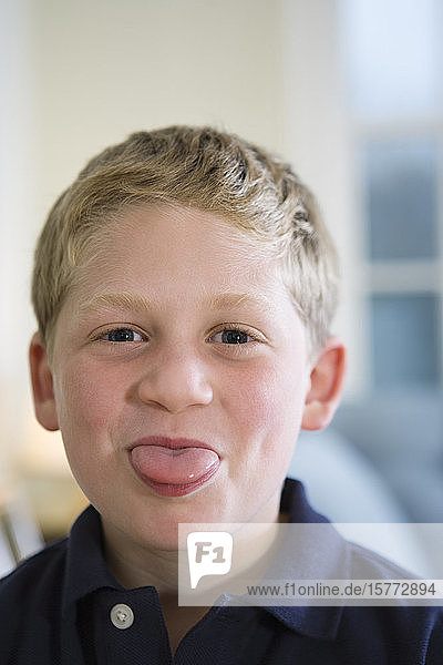 Porträt eines Jungen  der die Zunge herausstreckt.