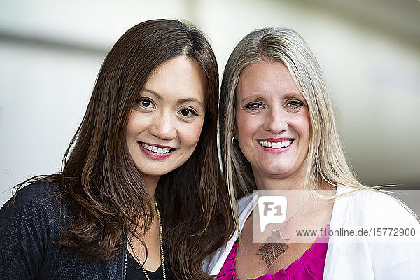 Zwei reife  berufstätige Geschäftsfrauen posieren für ein Foto an ihrer Arbeitsstelle: Edmonton  Alberta  Kanada