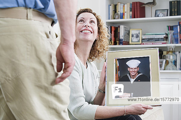 Frau zeigt Bild ihres Sohnes  der beim Militär arbeitet.