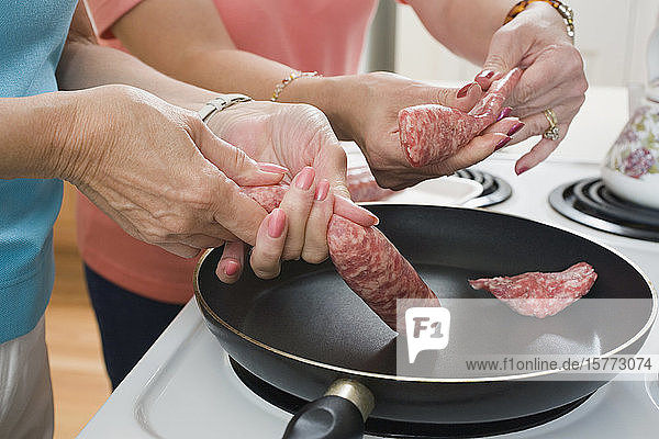 Mittelschnittansicht von zwei Frauen  die in der Küche Essen zubereiten