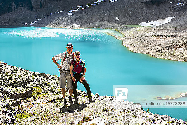 Female and Male hiker on rocky ridge with blue alpine lake in the background  Yoho National Park; Field  British Columbia  Canada