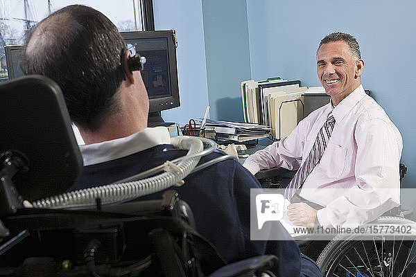 Geschäftsleute in Rollstühlen arbeiten gemeinsam in einem Büro