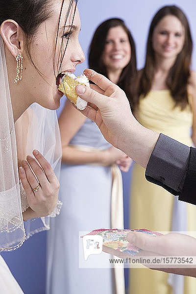 Seitenansicht einer Braut  die Kuchen isst.