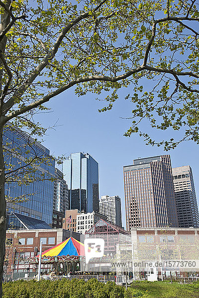 Colourful carousel in the foreground with skyscraper office towers in the background; Boston  Massachusetts  United States of America