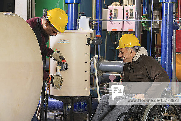 Disabled worker and a co-worker working in an industrial workplace