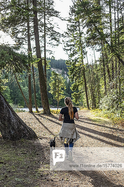 Mädchen geht mit ihrem Hund in einem Park spazieren; British Columbia  Kanada