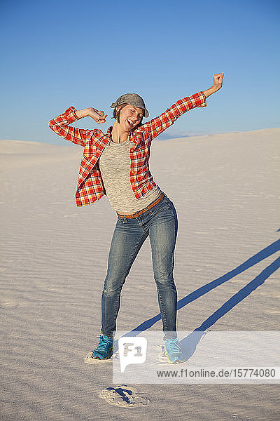 Carefree young woman on the white sand with blue sky White Sands National Monument; Alamogordo New Mexico United States of America