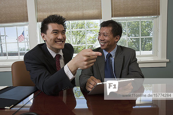 Businessmen sitting in their workplace laughing together