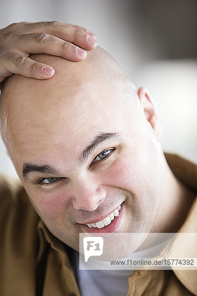 Porträt eines lächelnden Mannes mit Glatze.