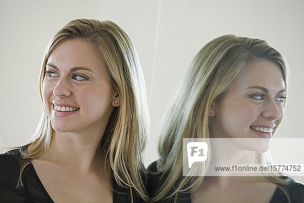 Mittlere erwachsene Frau lächelt vor einem Spiegel