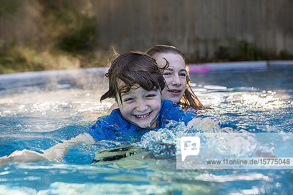 Ein Junge und ein Mädchen spielen im Pool im frühen Morgenlicht