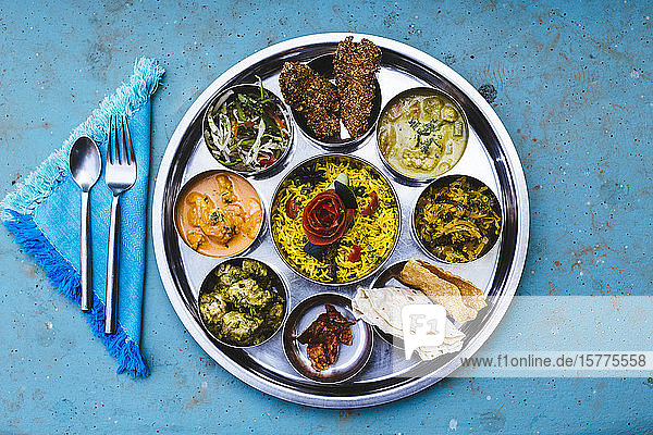 Nahaufnahme eines traditionellen indischen Mittagessens mit Reis  verschiedenen Currys  Essiggurken und Gemüse aus der Vogelperspektive.