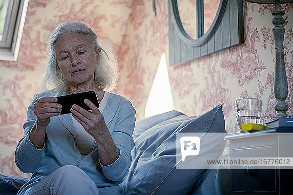 Ältere Frau schaut Video auf Smartphone