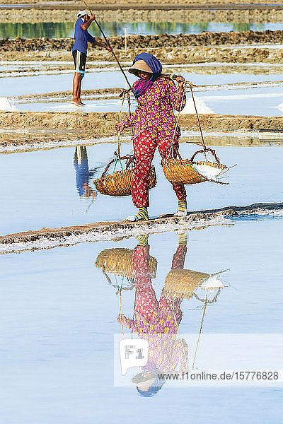 Frau mit Schulterstange bei der Ernte auf den Salzfeldern im Mündungsgebiet des Praek Tuek Chhu Flusses südlich der Stadt  Kampot  Kambodscha  Indochina  Südostasien  Asien