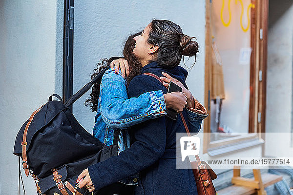 Lächelndes lesbisches Paar umarmt sich im Urlaub in der Stadt