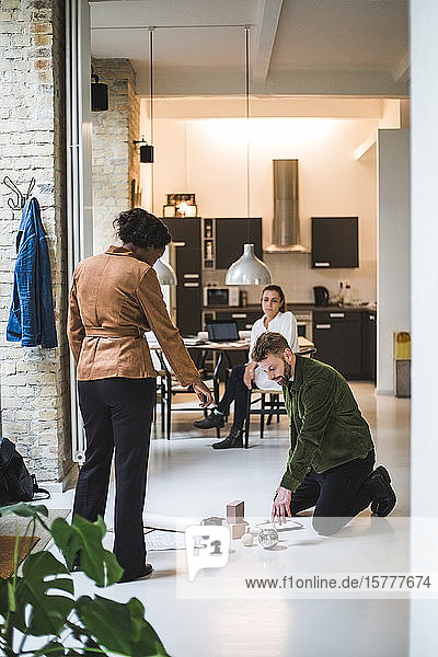Männliche und weibliche Architekten  die als Freiberufler arbeiten und zu Hause im Hintergrund sitzen