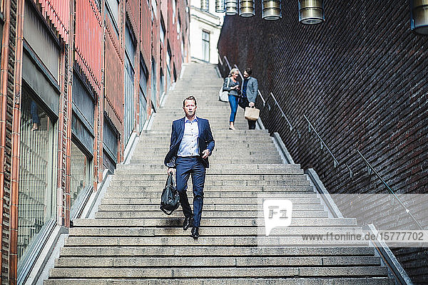 Porträt eines reifen Geschäftsmannes beim Treppensteigen