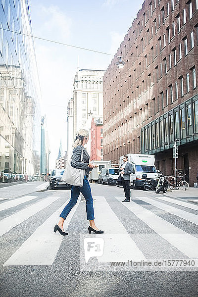 Businesswoman crossing road in city