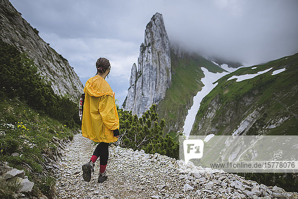 Frau mit gelber Jacke in den Bergen in Appenzell  Schweiz