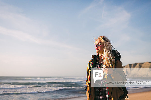 Frau mit Jacke am Strand