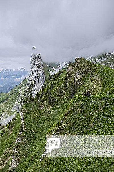 Frau sitzt auf einem Berg in Appenzell  Schweiz