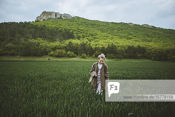 Woman wearing jacket walking in field in Crimea  Ukraine