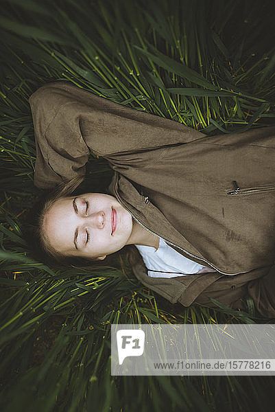 Smiling woman lying down in grass