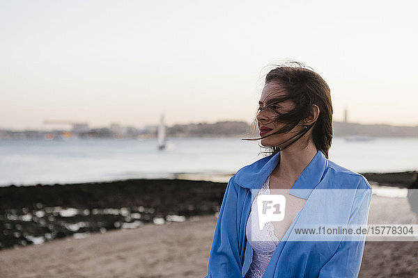 Woman wearing blue jacket by sea