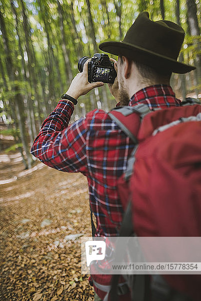 Man taking photograph in forest