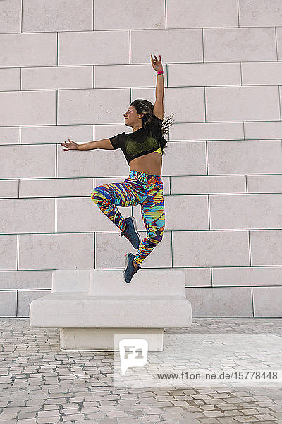 Woman jumping by wall