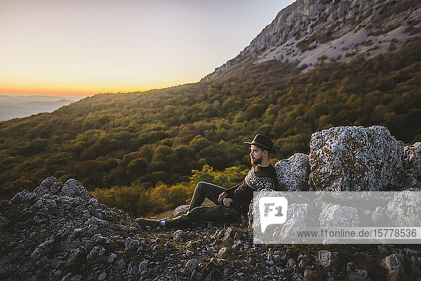Man lying on rock by mountain