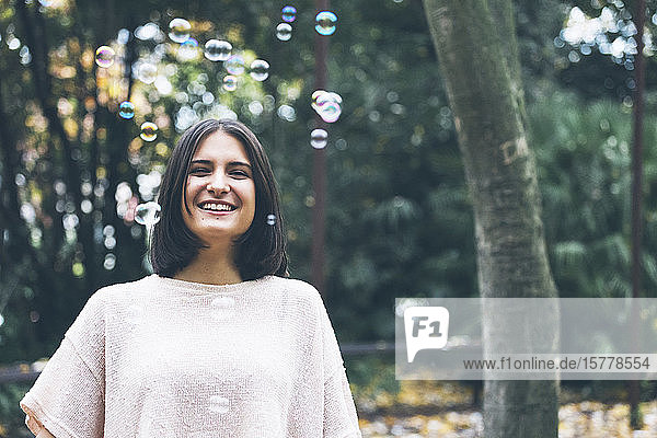 Smiling teenage girl under bubbles