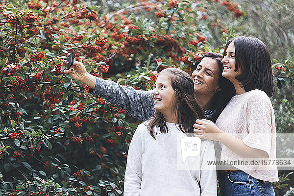 Mutter und Töchter lächelnd und nehmen Selfie