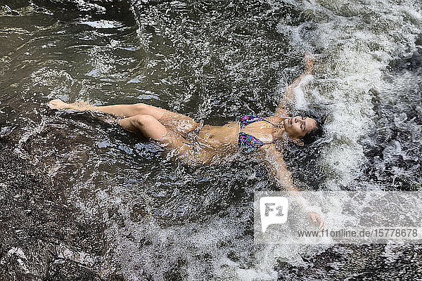 Woman lying in stream