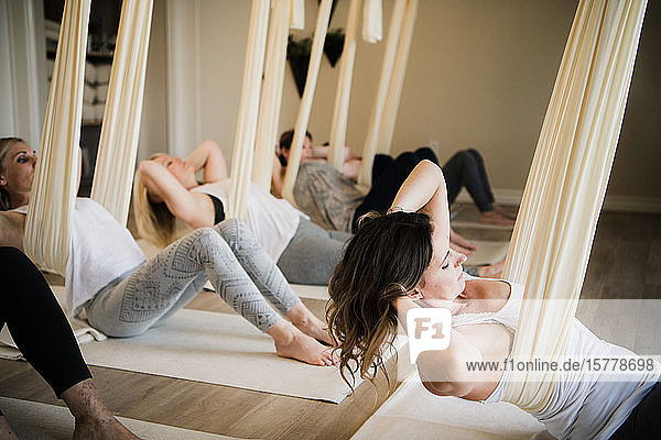 Women doing aerial yoga at retreat