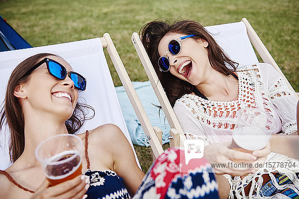 Friends sitting in deck chairs in music festival