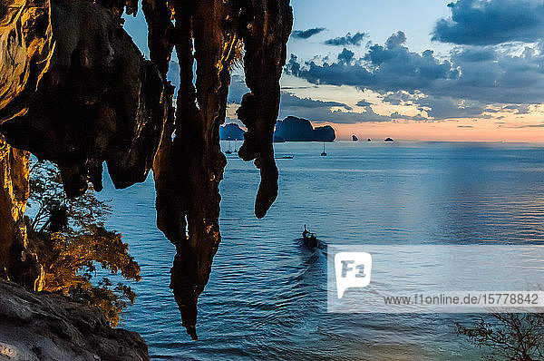 Überhängender Felsen  Boot und Sonnenuntergang im Hintergrund  Tonsai  Krabi  Thailand