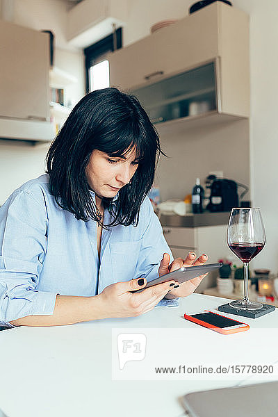 Frau sitzt am Tisch mit digitalem Tablett