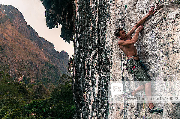 Man sport climbing on limestone  Thakhek  Laos